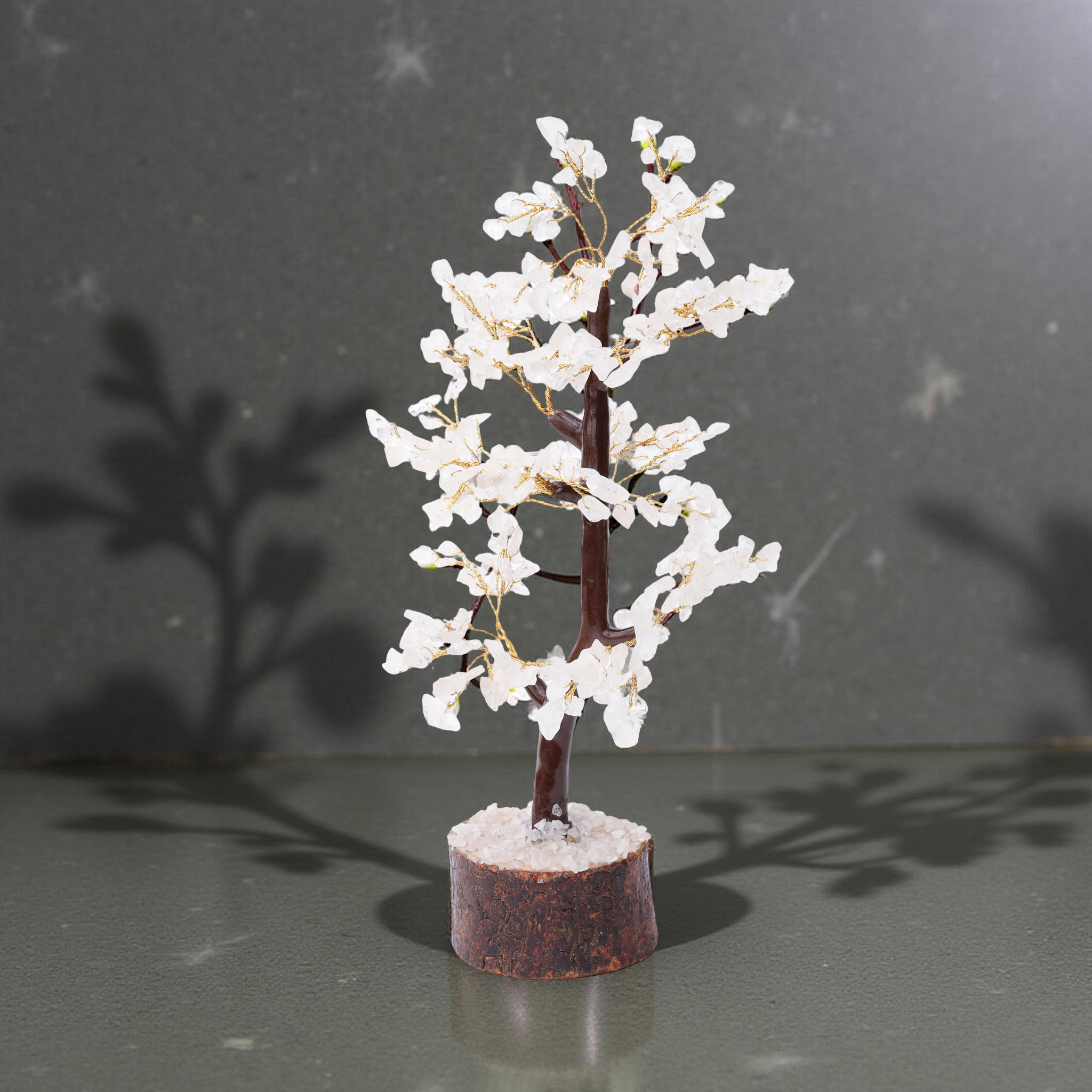 AstroViz handcrafted white moonstone petal chip tree with distinctive looping inner trunk on coarse crystal chip dark bark wood base — green-grey studio surface
--4