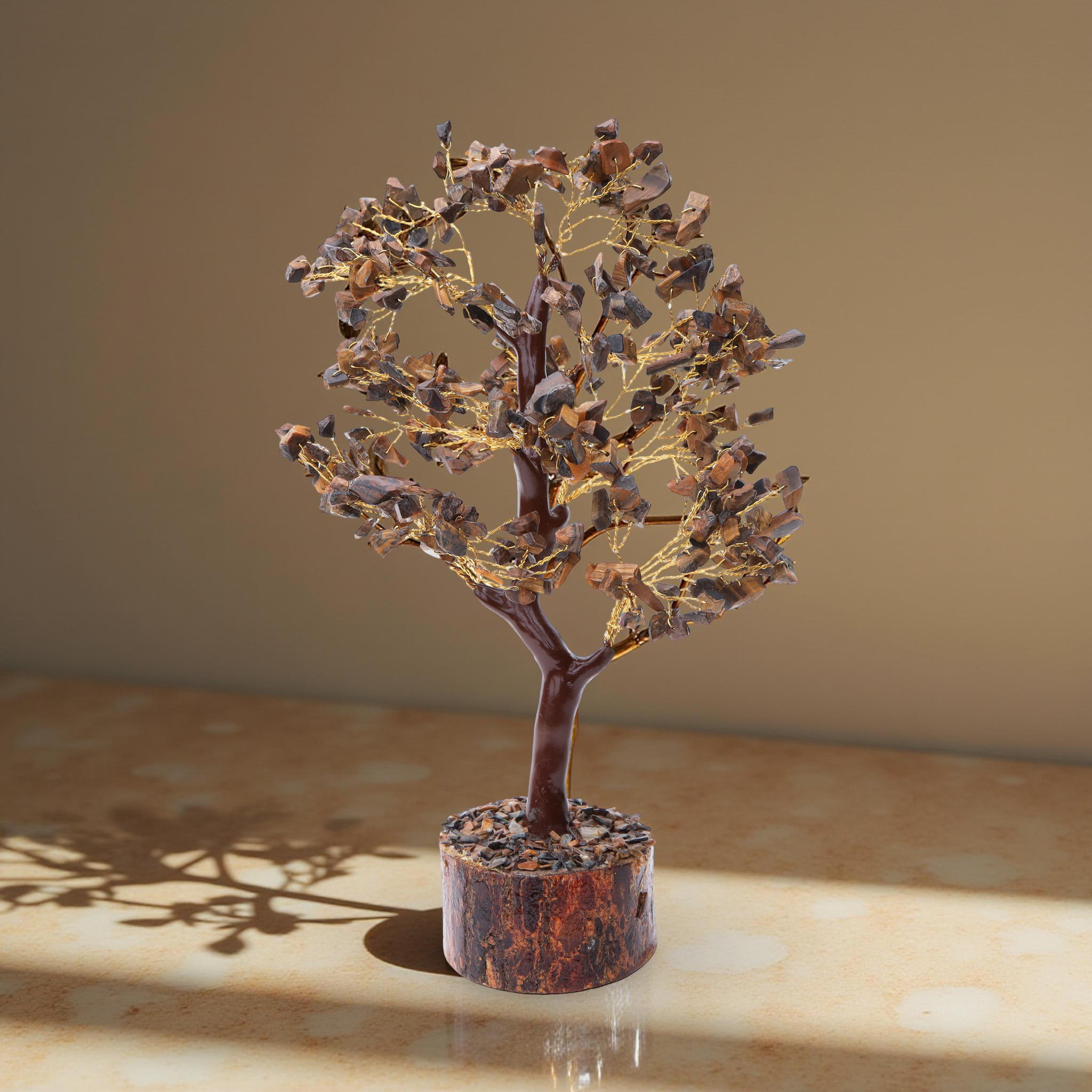 AstroViz Tiger's Eye crystal tree casting a shadow on a marble surface.--4
