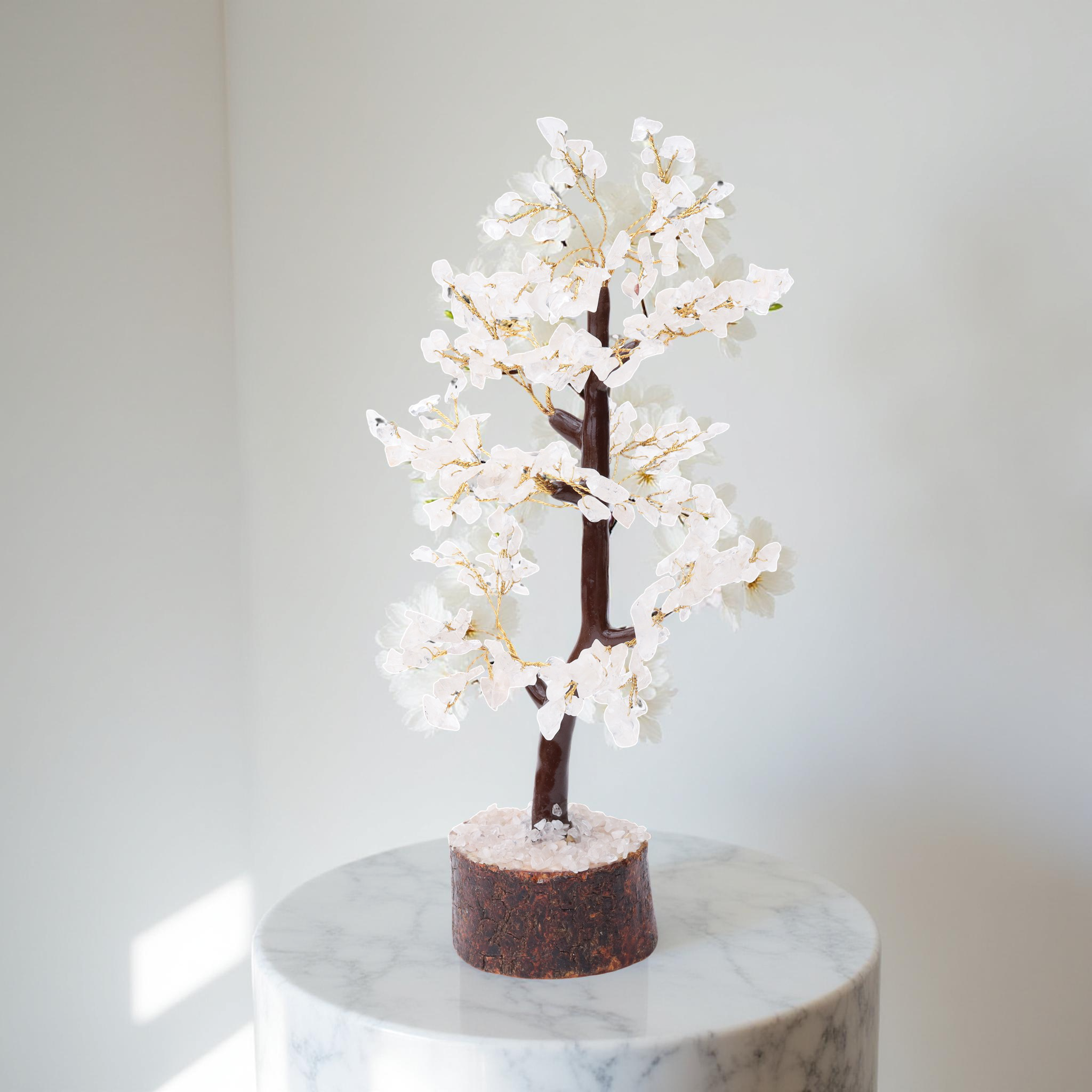 AstroViz handcrafted white moonstone gemstone chip decorative blossom tree with sculptural looping trunk placed on white marble pedestal in bright white interior setting
--6
