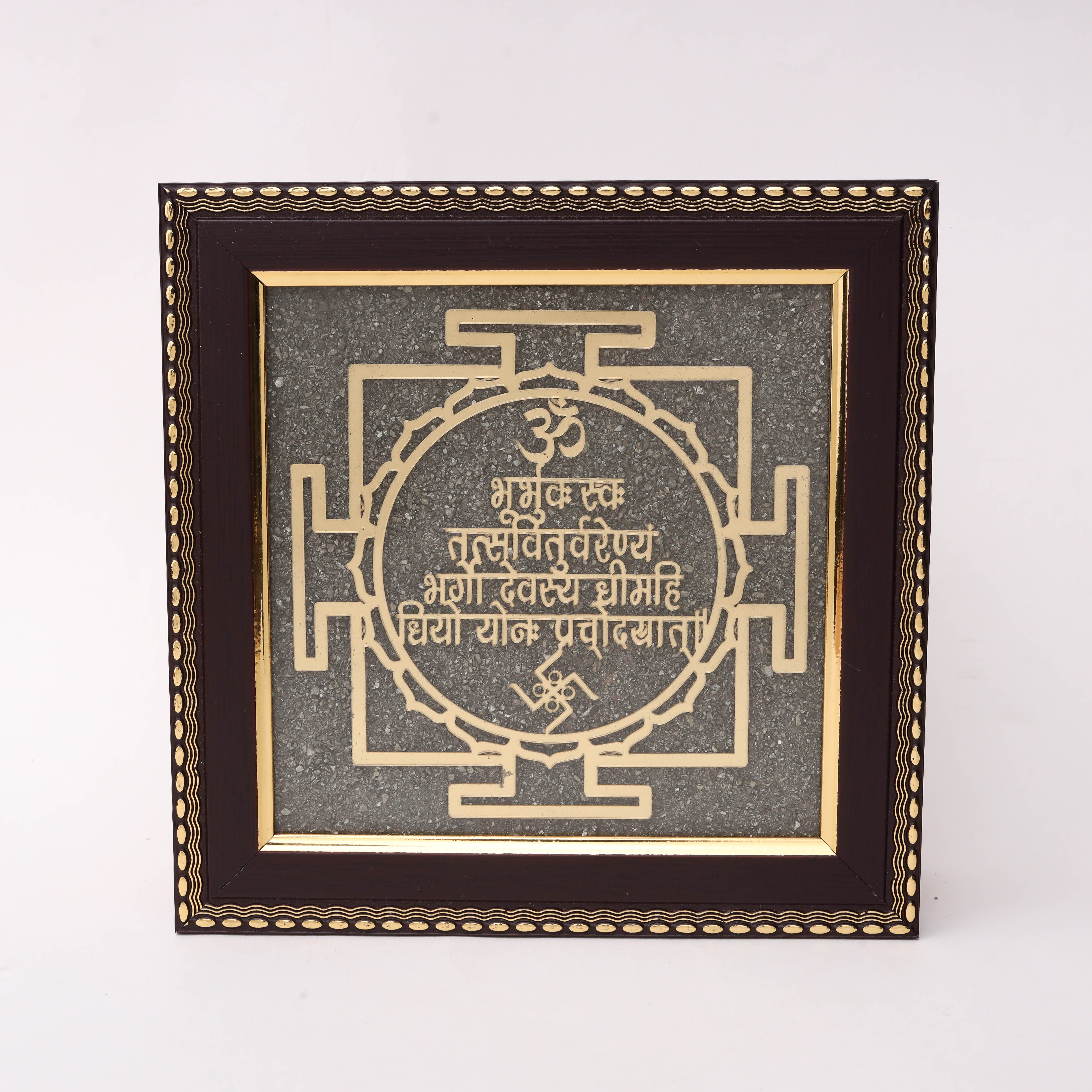 Gold laser-cut Gayatri Mantra Sanskrit text within circular petal border and traditional Yantra square geometry with Om and Swastik symbols on charcoal stone texture background in dark wood decorative frame--1