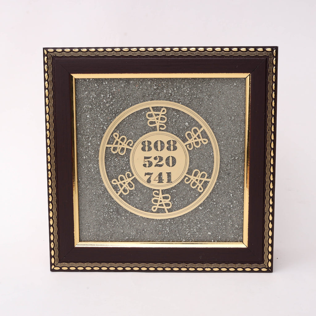 Gold laser-cut Solfeggio Frequency numbers 808 520 741 in circular double-ring design with ornate knot motifs on charcoal stone texture background in dark wood decorative frame