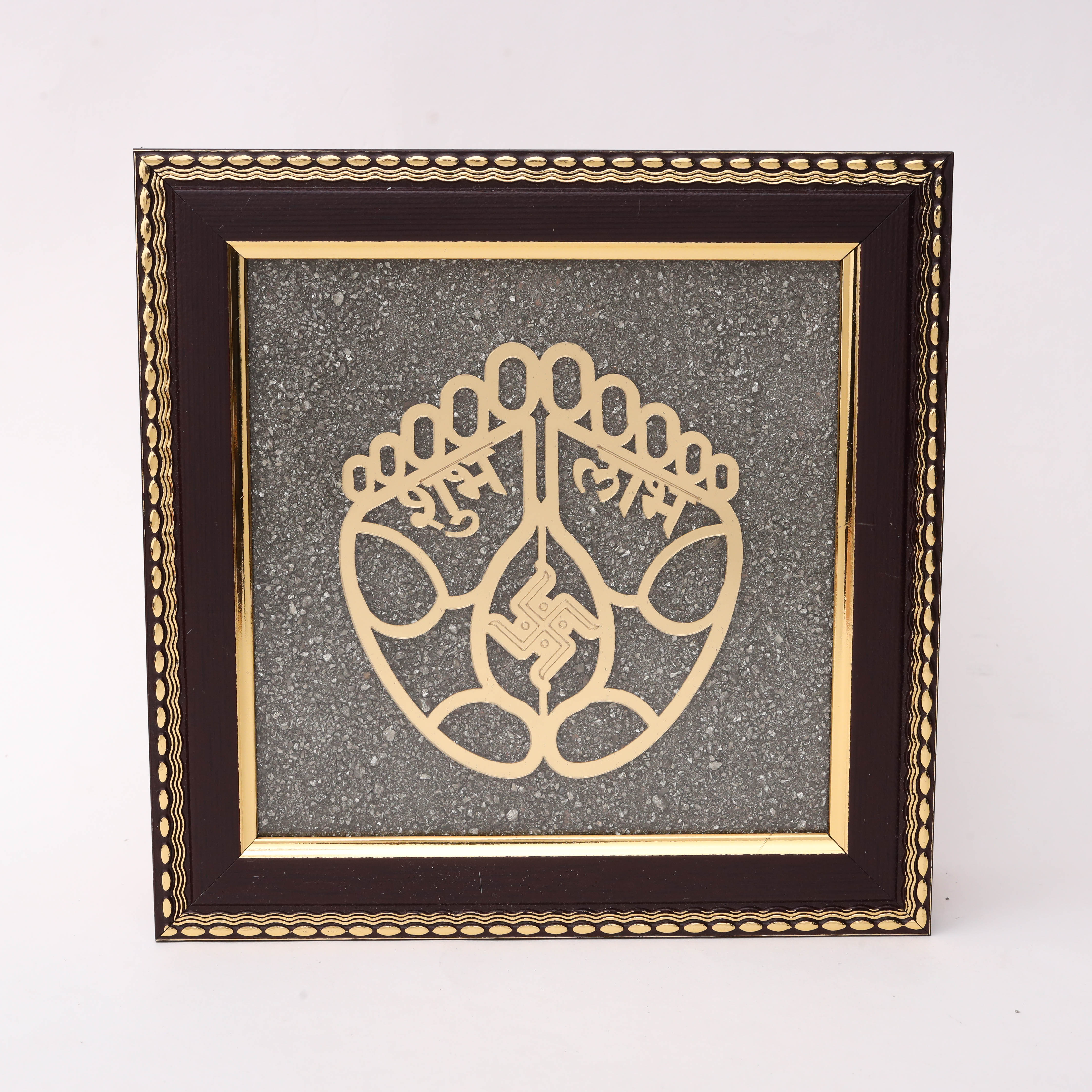 Gold laser-cut Charan Paduka sacred feet with Shubh Labh Devanagari inscription and Swastik symbol on charcoal stone texture background in dark wood decorative frame
--1