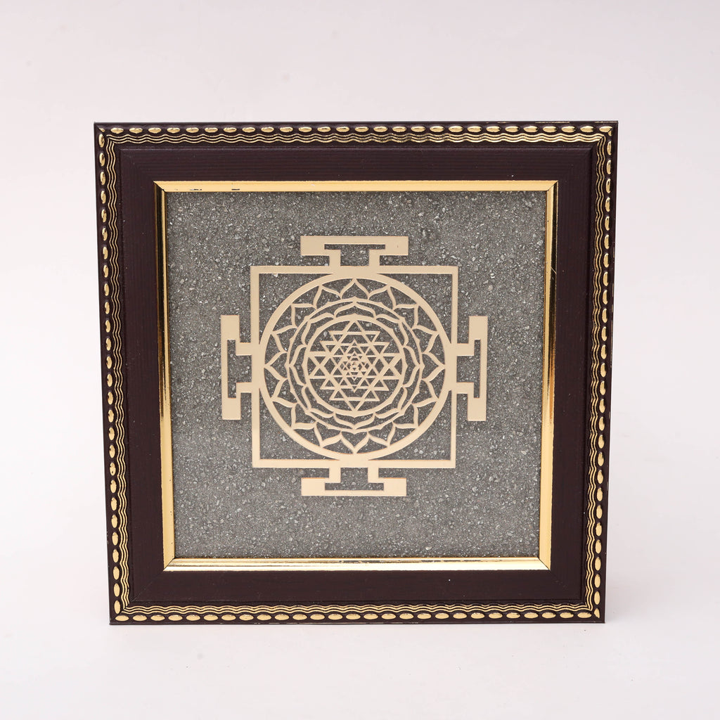 AstroViz Sri Yantra gold-tone laser-cut motif on grey stone chip background in dark brown ornate embossed wooden frame