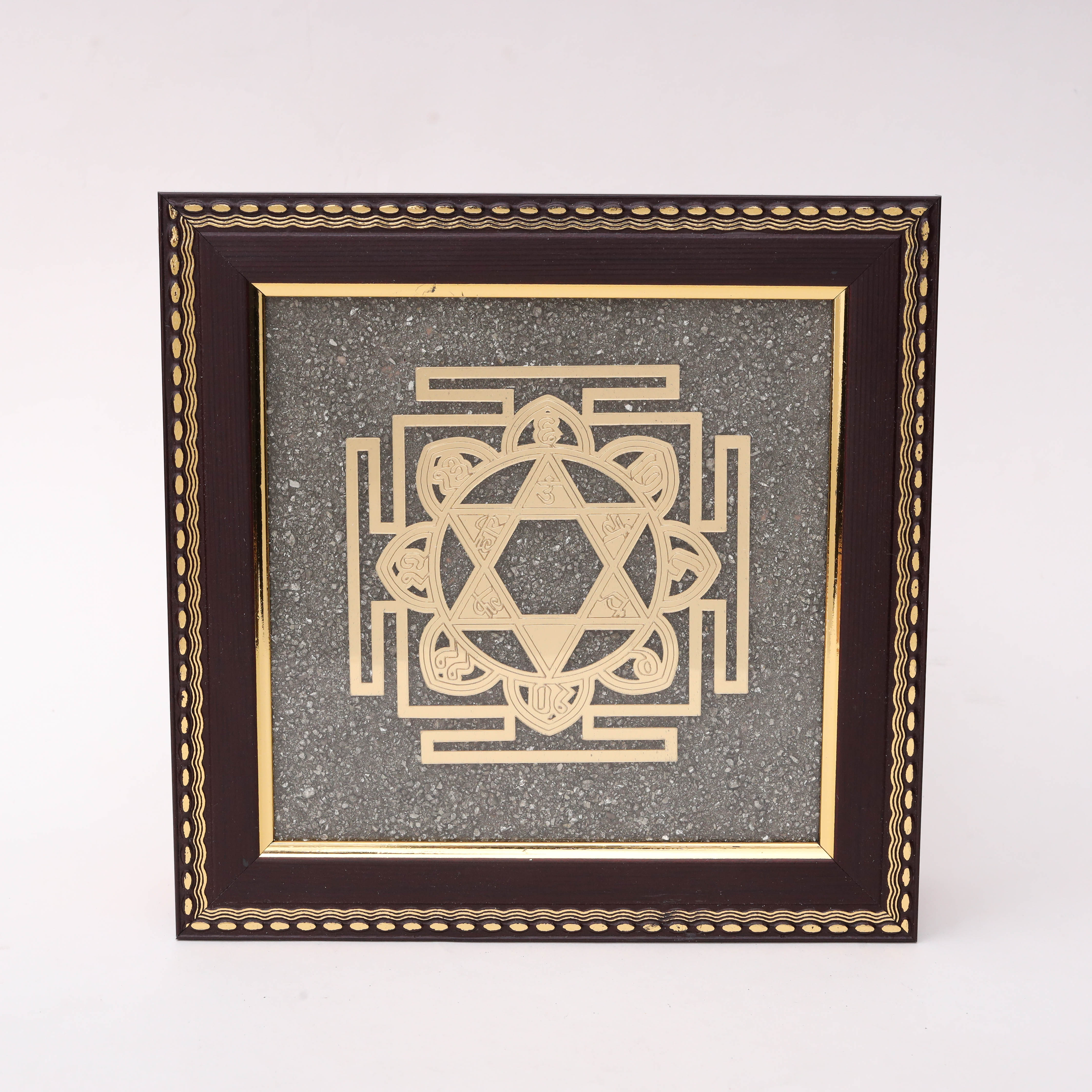 AstroViz Surya Yantra gold-tone metallic motif on textured grey stone background in a dark brown ornate wooden frame.--1