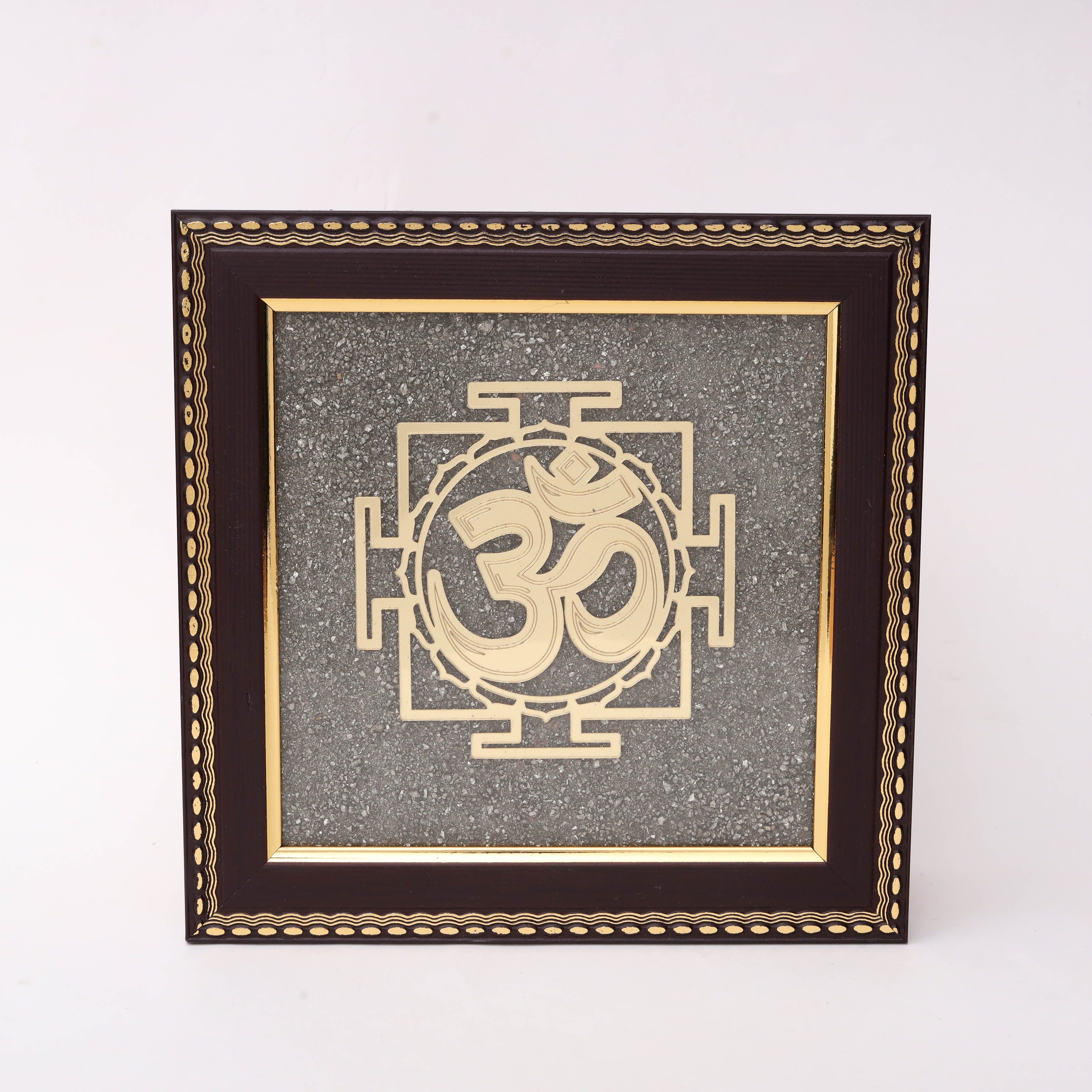 AstroViz Om gold-tone laser-cut motif on textured grey stone chip background in a dark brown ornate embossed wooden frame.--1