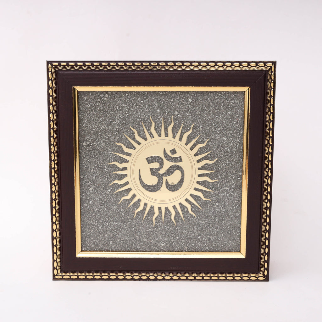AstroViz Ganesha and Lakshmi gold-tone laser-cut motif on textured grey stone chip background in dark brown ornate wooden frame.

